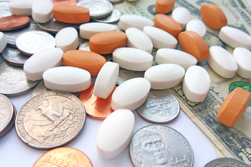 Pills, tablets and capsules with American coins on dollar usa background. Pharmacy and money theme, health care, drug prescription for treatment medication