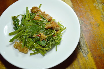 fried Chayote sprout with crispy chicken on plate
