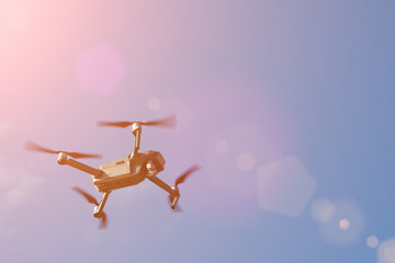 Drone quadcopter with digital camera. Drone hovering in blue sky, sunlight