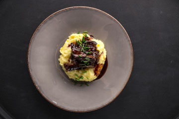 Beef stew and mashed potatoes top view on black background