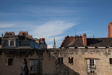 woman looking traditional france facade and roof in the city on Nantes in a sunny day with clear sky - body copy