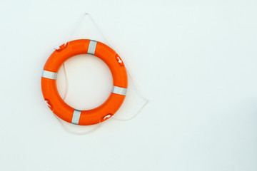 Orange lifebelt with rope hang on the wall near the swimming pool with copy space.