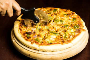 Pan Pizza cutting side closeup with dark brown wood