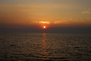 Fototapeta premium Sky orange light of the sun through the clouds in the sky at Bangpu Samutprakan