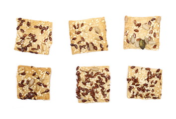 Salty integral flour crackers with linseed and sunflower seeds isolated on white background, top view