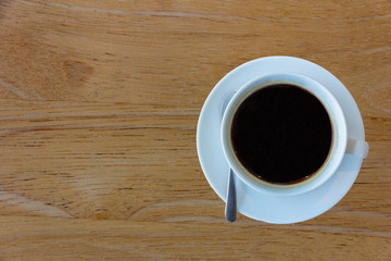Top view a cup of black coffee on old warm wooden background