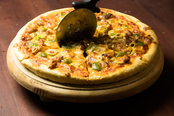 Pan Pizza cutting side closeup with dark brown wood