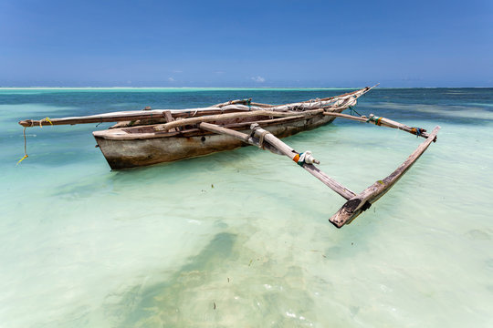 landestypische h&ouml;lzerne Dhau im kristallklaren meer vor der insel Sansibar am traumstrand im indischen ozean