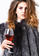 Girl enjoy luxury lifestyle attributes. Fashion model long hair fur coat or vest hold wineglass....