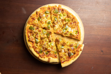 Pan Pizza slice take from top view with dark brown wood