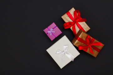 Gift boxes with ribbons on black background.