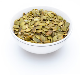 Pumpkin seeds (peeled seeds) in white bowl (Various nuts collection). Isolated on white background.