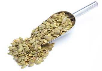Pumpkin seeds (peeled seeds) in metal shovel (Collection of various nuts). Isolated on white background.