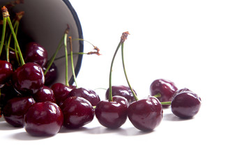 Red sweet cherry in white cup isolate on white.