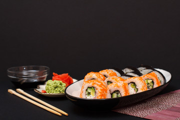 Uramaki California. Sushi rolls and plate with red pickled ginger and wasabi.