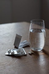 a glass of water, pills, blister and instruction leaflet