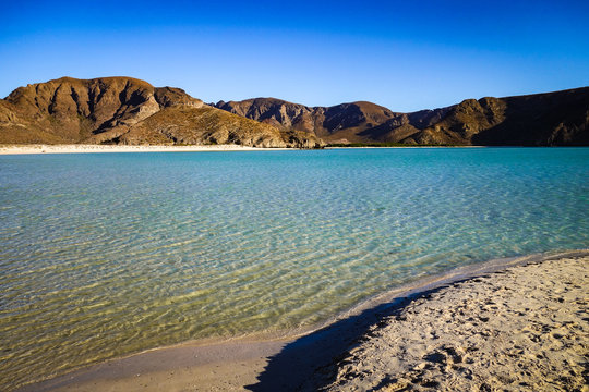 The shallow, clear, turquoise waters of Playa Balandra ripple calmly in the late afternoon sun, near La Paz in Baja California Sur