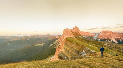 Silhouette of the man on top the peak of mountain on sunrise sky , Sport and active life conceptual design. Seceda mountain, Dolomity