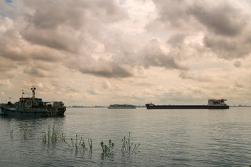 Cruise ship and barge  on Volga River. Dramatic sky clouds as background.