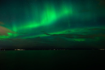 Naklejka premium Green Aurora Borealis on night sky.