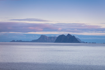 Fototapeta premium Island on the horizon. Beautiful sea landscape in the evening. Wild nature of Norway.