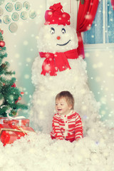 Happy little boy in living room with christmas decoration