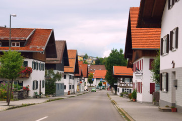 Fototapeta na wymiar Strasse in Pfronten Weißbach mit typisch bayrischen Häusern 