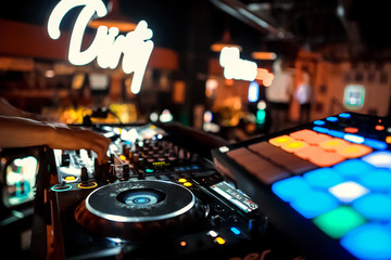 Dj mixes the track in the nightclub at party