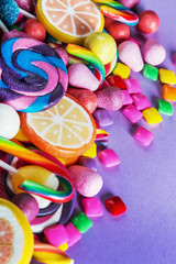  sweets, lollipop, chewing gum, candies etc on lilac background