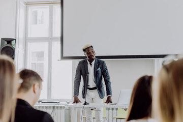 Smiling afro american man boss talking to business team in conference room. Business conference. Business meeting.