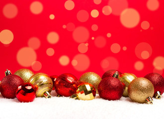 Christmas background with baubles in snow on red background. Front view. Place for text.