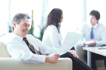 Fototapeta premium businessman pondering a document sitting in a modern office