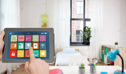 automation, internet of things and technology concept - close up of male hands using tablet pc computer with smart home icons on screen over kids room background