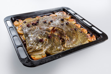 Turbot fish in baking pan oven with potatoes olives and aromatic herbs
