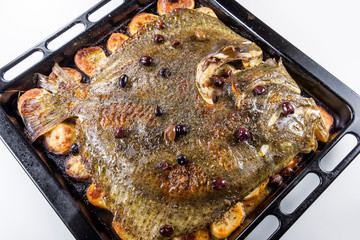 Turbot fish in baking pan oven with potatoes olives and aromatic herbs