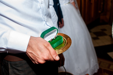 Obraz premium groom holding wedding rings in the green box