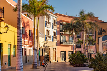 Fototapeta na wymiar Colourful houses, palm on street Puerto de la Cruz town Tenerife Canary Islands