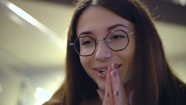 Young attractive brunette girl in glasses practicing to speak earnestly and sincerely on job interview