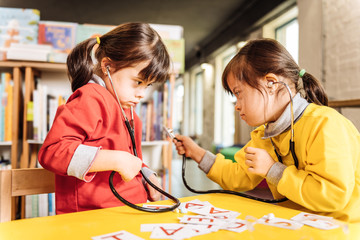 Dark-eyed children with Down syndrome playing on kindergarten