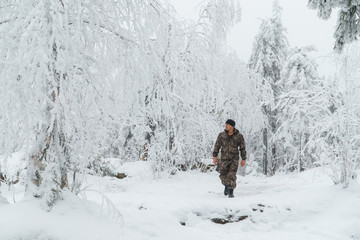 Fototapeta na wymiar Man hiker walking in beautiful winter forest