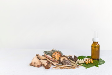 Dried herbs and Herbal medicine pill and Natural extracts cosmetics in a bottle on a white wooden table and white background, image with copy space for text or image.