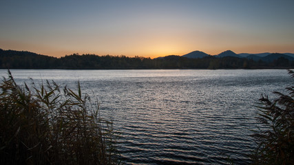 Cloudless dawn over the lake with hills on the other shore