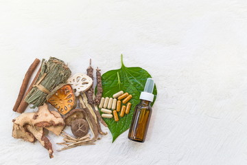 Top view of Dried herbs and Herbal medicine pill and Natural extracts cosmetics in a bottle on a white wooden table, image with copy space for text or image.