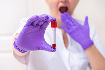 Obraz premium Scared woman holding blood sample tube