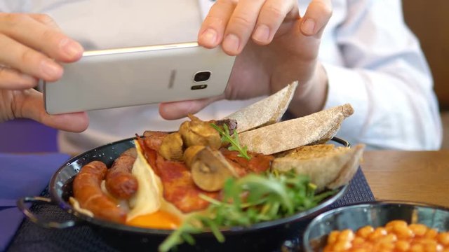 Man taking picture of English breakfast in 4k slow motion 60fps