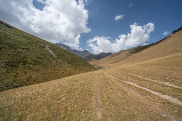 Fototapeta na wymiar Small road between the mountains in Kyrgyzstan