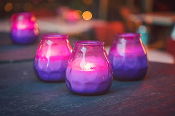 Burning purple and pink candles on the table