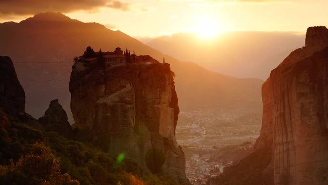 Scenic sunset sky over holy Trinity monastery on cliff in Meteora, Thessaly Greece. Greek destinations. Time lapse
