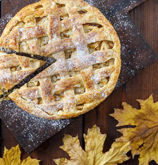 whole round apple pie on a rectangular old brown board