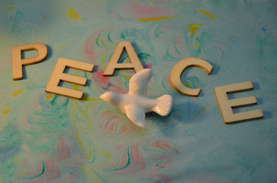 Peace schriftzug mit fierdenstaube auf buntem Hintergrund